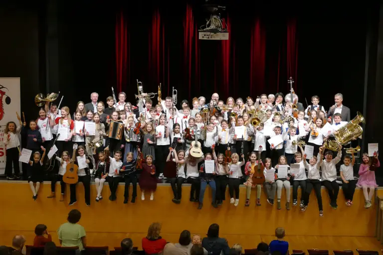 Eine große Gruppe Kinder mit Musikinstrumenten auf einer Bühne