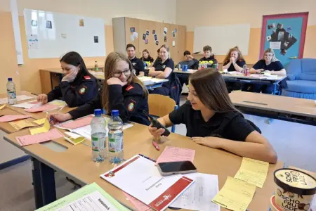 Eine Gruppe von Jugendlichen sitzt an Schulbänken