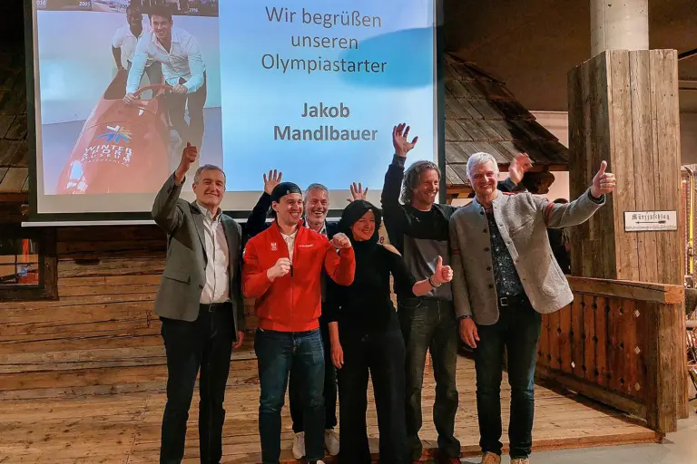 Sechs Menschen stehen nebeneinander und jubeln.