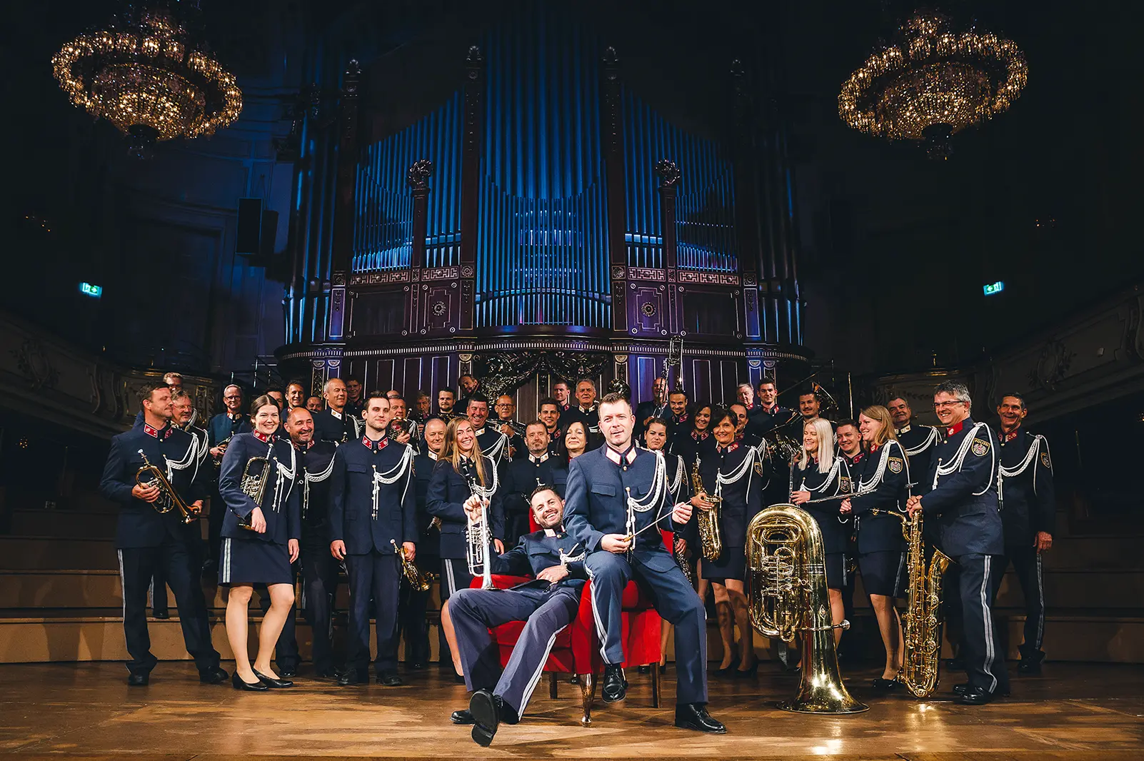 Eine große Gruppe von MusikerInnen in Uniform vor einer Orgel