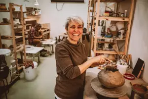 Eine Frau in einem Atelier an einer Töpferscheibe