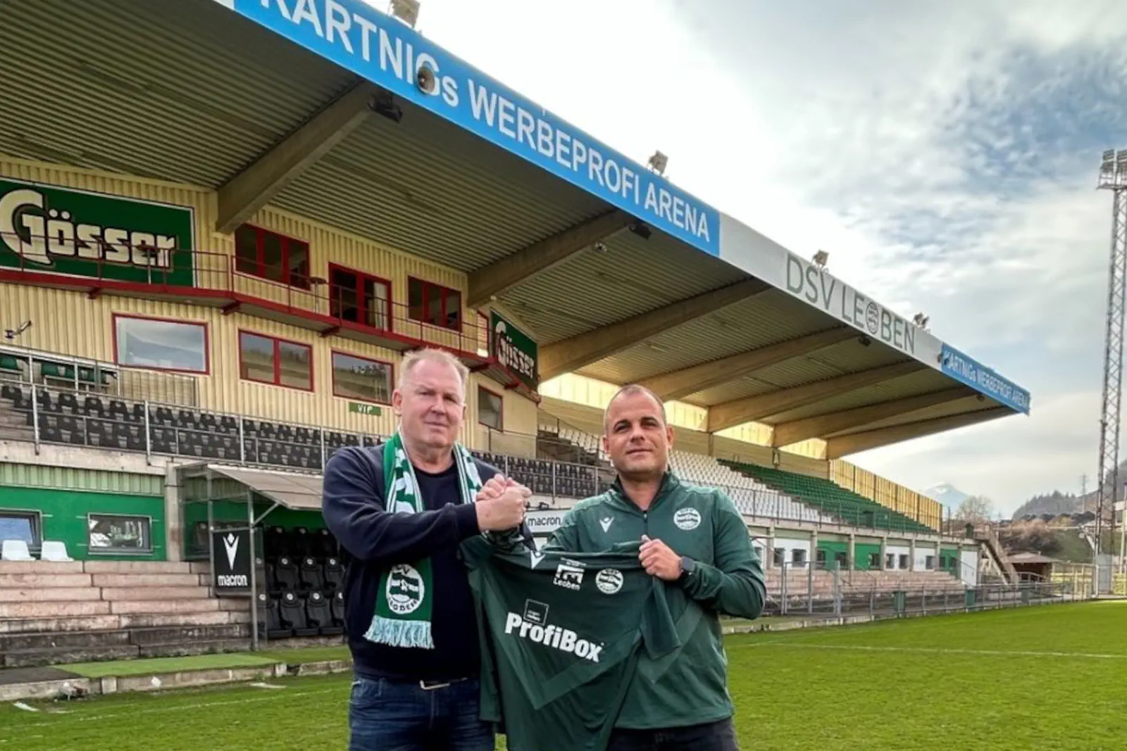 Zwei Männer halten ein Trikot.