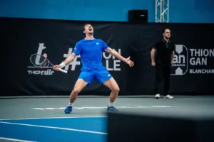 Ein Tennisspieler jubelt ausgelassen auf einem Tennisplatz.