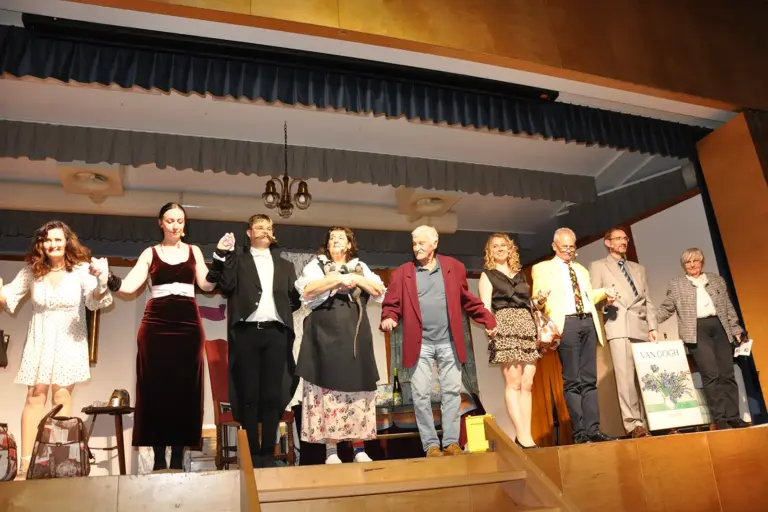 Ein Ensemble von SchauspielerInnen auf einer Theaterbühne