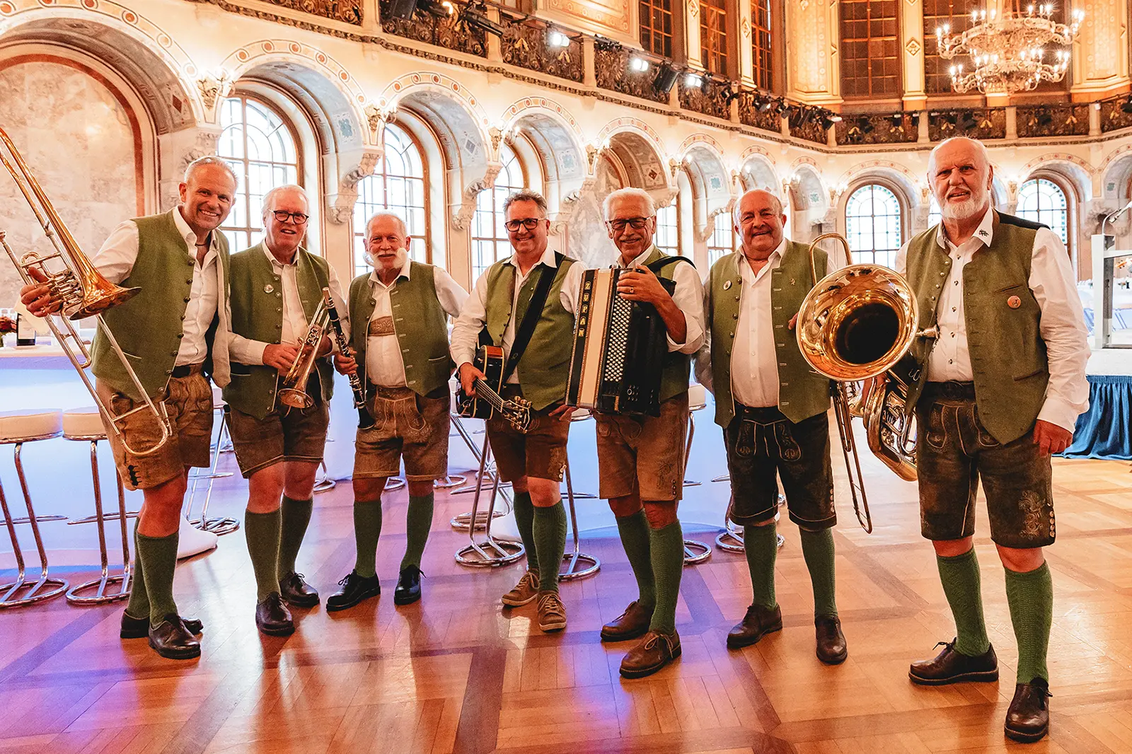 Sieben Männer in Tracht mit Musikinstrumenten