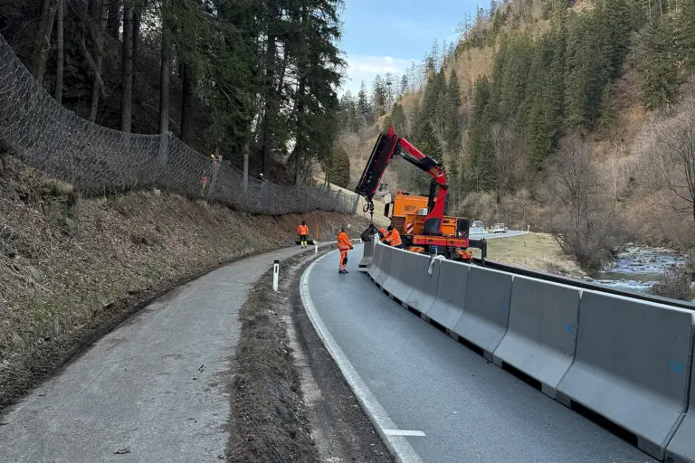 Männer in Arbeitskleidung mit Baufahrzeugen auf einer Straße