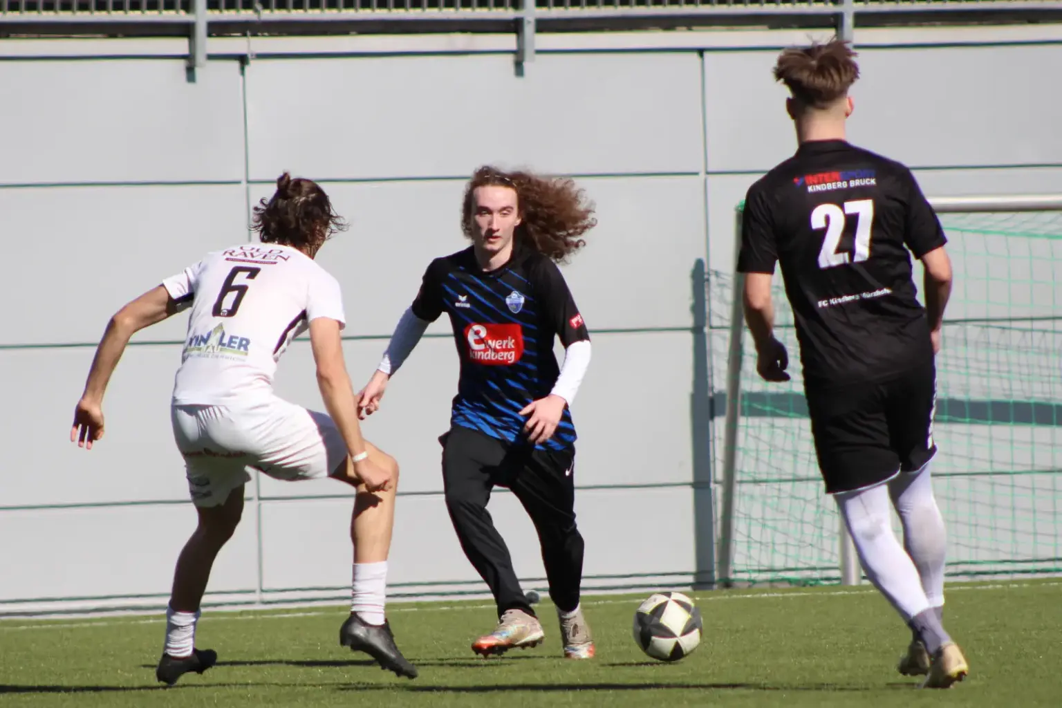 Drei Fußballer und ein Ball.