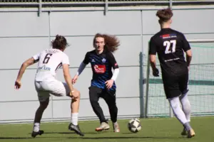 Drei Fußballer und ein Ball.