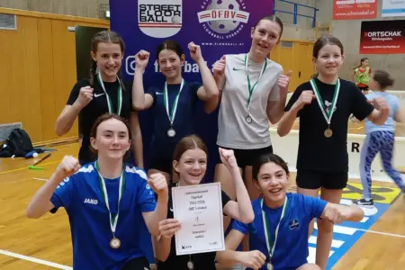 Eine Gruppe von Mädchen jubeln gemeinsam, alle haben Medaillen um.