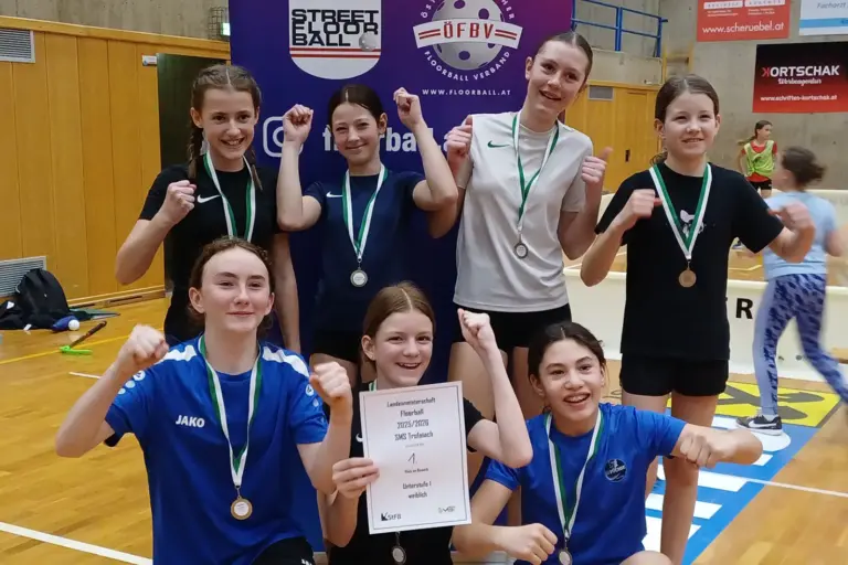 Rekordteilnehmer beim steirischen Floorball-Schulturnier in Trofaiach Eine Gruppe von Mädchen jubeln gemeinsam, alle haben Medaillen um.