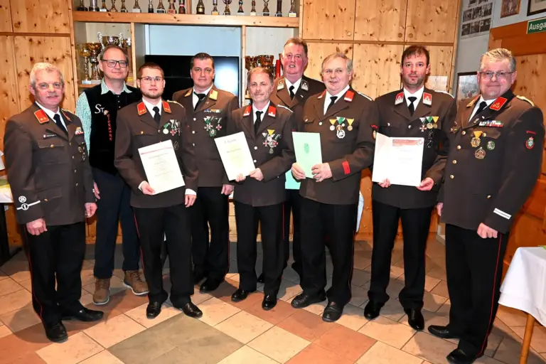 Neun Männer in Uniform zeigen Urkunden