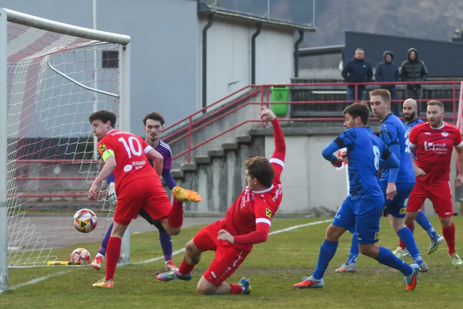Ein roter Spieler rutscht in den Ball