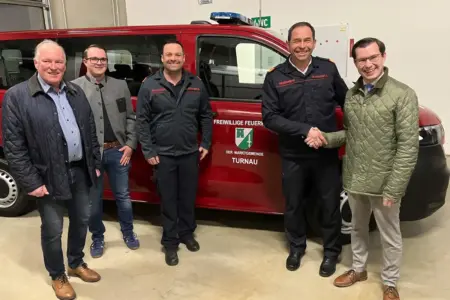 Fünf Männer vor einem Feuerwehrfahrzeug