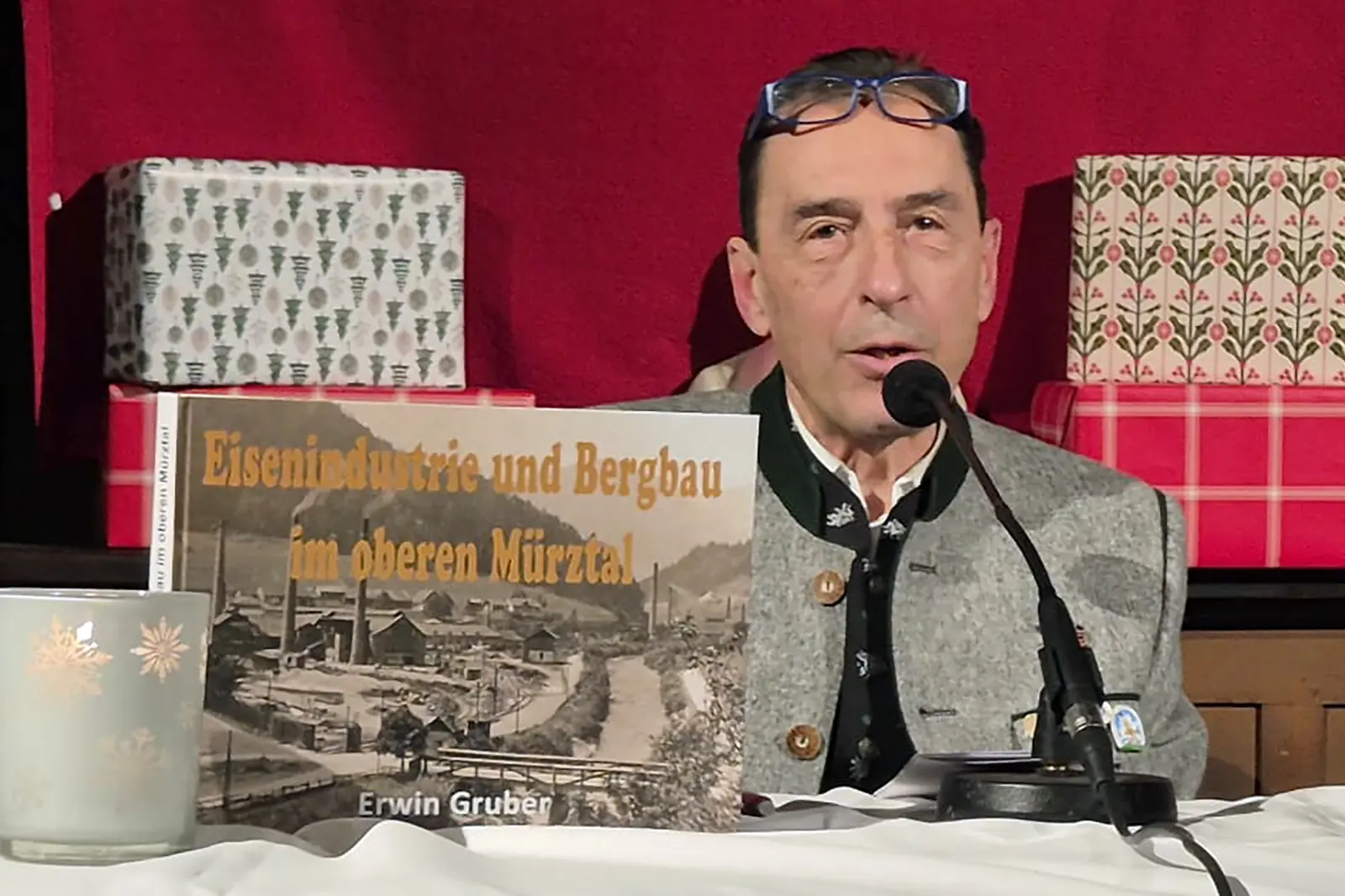 Ein Mann mit einem Buch vor einem Mikrofon