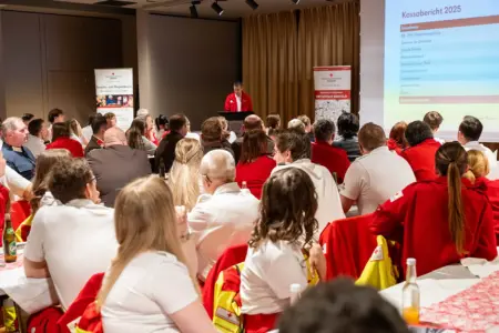 Ein Mann spricht in einem großen Saal vor vielen Personen in Uniform