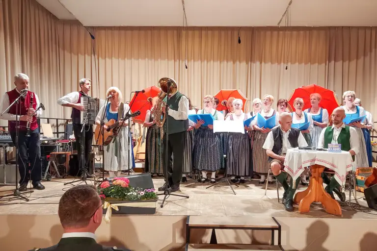 Eine Gruppe von Sängerinnen und Musikern spielen und singen auf einer Bühne