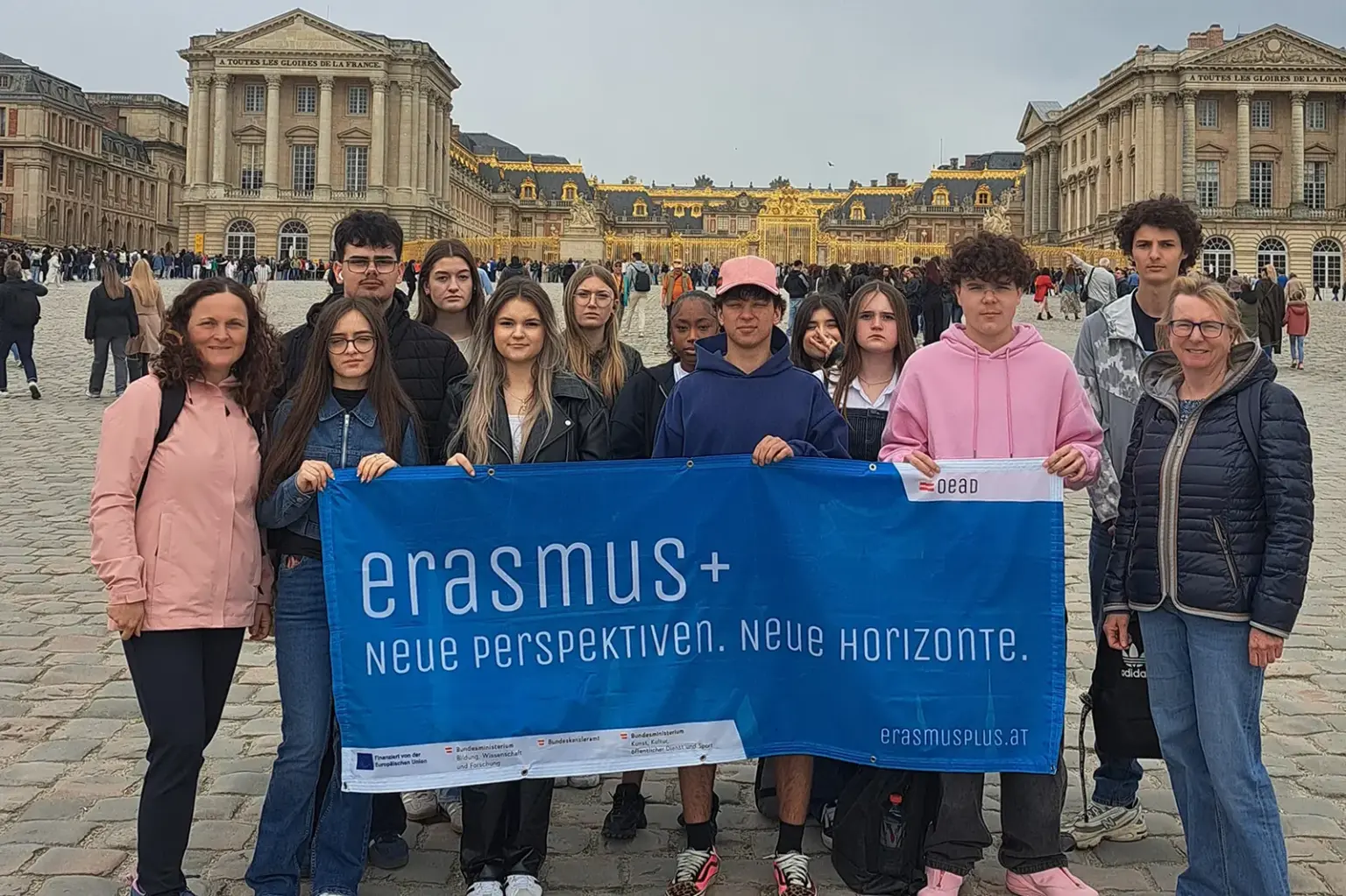 Eine Gruppe von Jugendlichen steht mit einem Transparent vor einem Prachtbau.