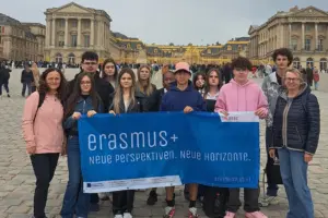 Eine Gruppe von Jugendlichen steht mit einem Transparent vor einem Prachtbau.