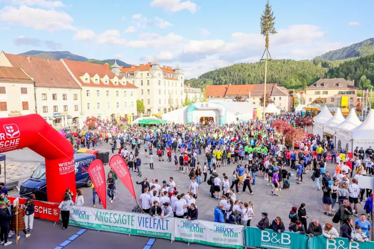 Viele Personen stehen auf einem großen Platz mit mehreren Zelten
