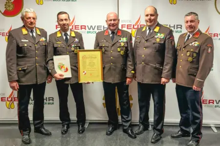 Fünf Männer in Uniform mit zwei Urkunden