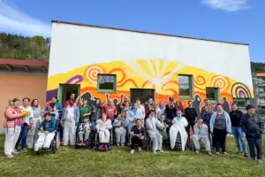 Eine Gruppe von Personen steht vor einer bunten Wand