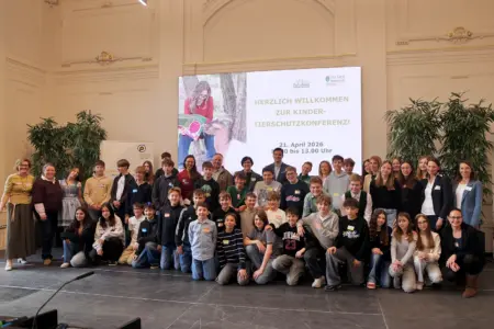 Eine große Gruppe von Jugendlichen mit mehreren Erwachsenen in einer großen Halle
