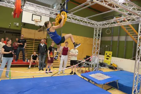 Ein Mädchen turnt an einem Klettergerüst