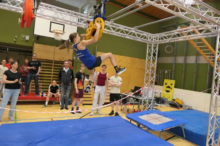 Ein Mädchen turnt an einem Klettergerüst