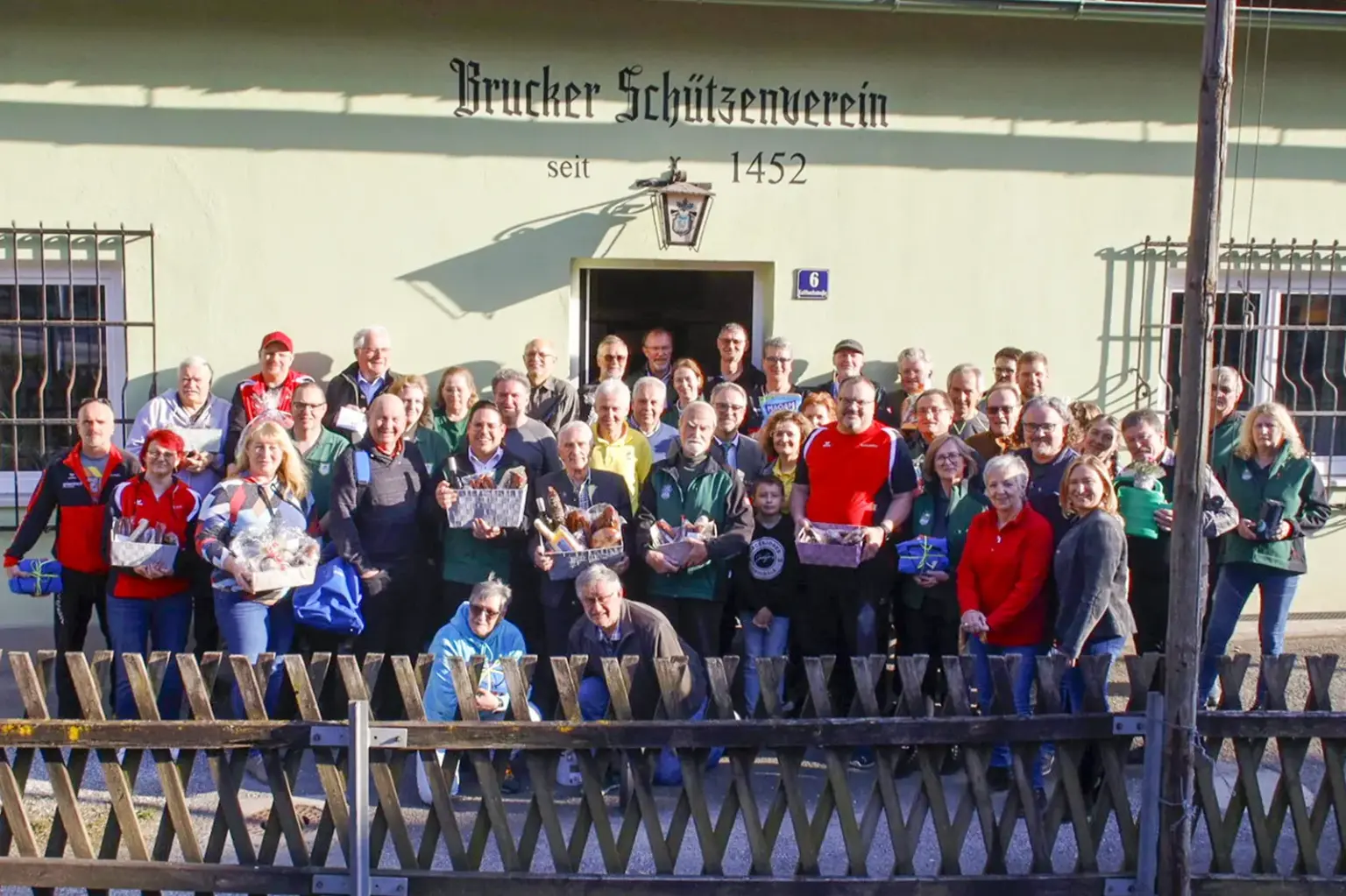 Auf dem Bild ist eine größere Gruppe von Mitgliedern vor dem Gebäude des „Brucker Schützenvereins“ zu sehen.