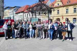 Eine große Gruppe von Personen präsentieren Flaschen auf einem großen Platz