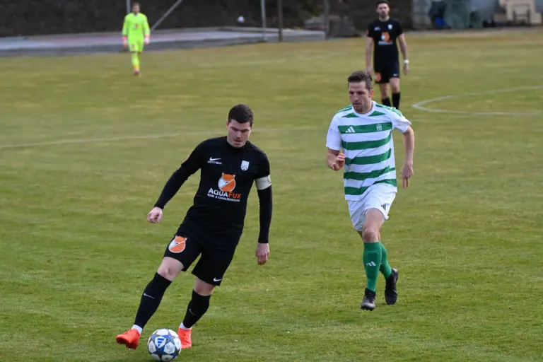 Zwei Spieler kämpfen um den Ball.