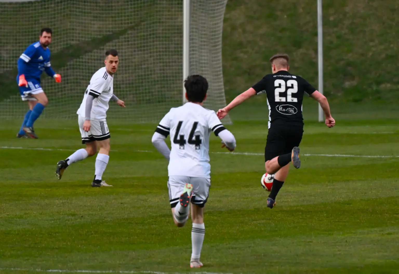 Drei Spieler sind rund um den Ball.