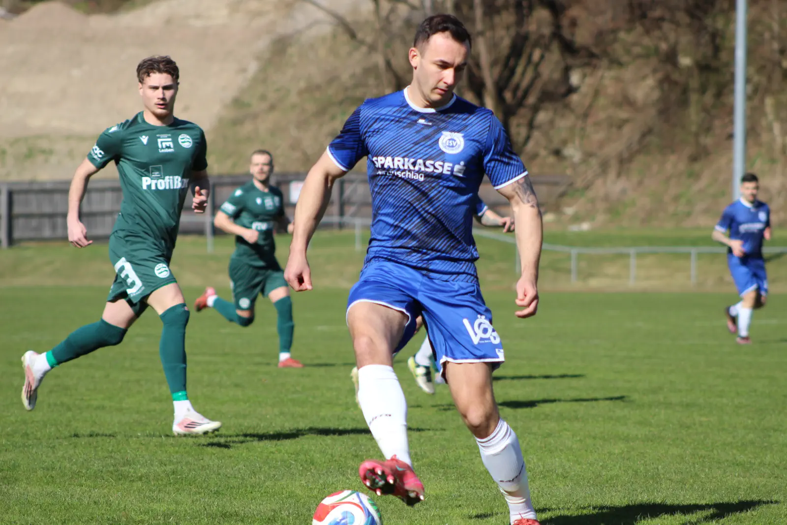 Ein Fußballer versucht den Ball zu stoppen.