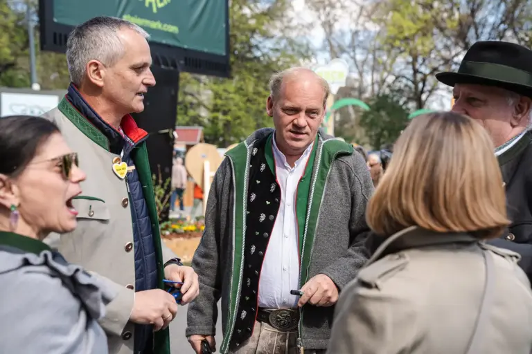 Ein Musiker in steirischer Tracht unterhält sich mit anderen Personen.