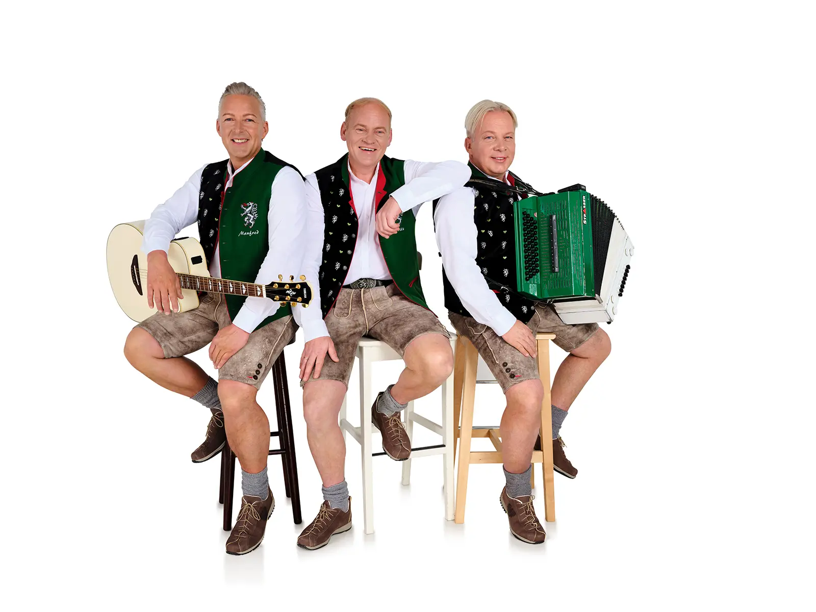 Drei Volksmusiker in Tracht zeigen sich mit ihren Musikinstrumenten.