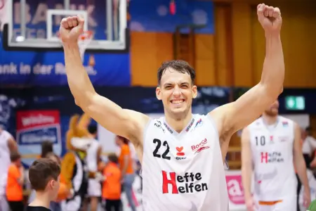 Ein Mann jubelt in einer Basketballhalle