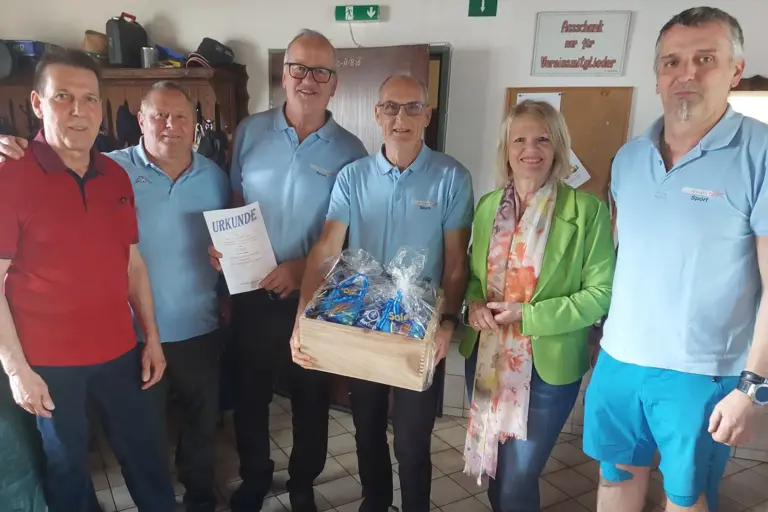 Fünf Männer und eine Frau mit einer Urkunde und einer Kiste mit Preisen