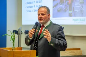 Ein Mann im Steireranzug spricht an einem Rednerpult stehend in ein Handmikrofon