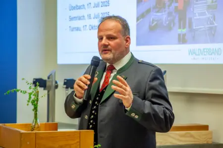 Ein Mann im Steireranzug spricht an einem Rednerpult stehend in ein Handmikrofon