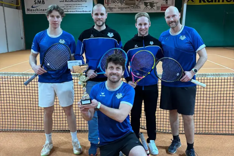 Fünf Männer stehen mit einem Pokal auf einem Tennisplatz