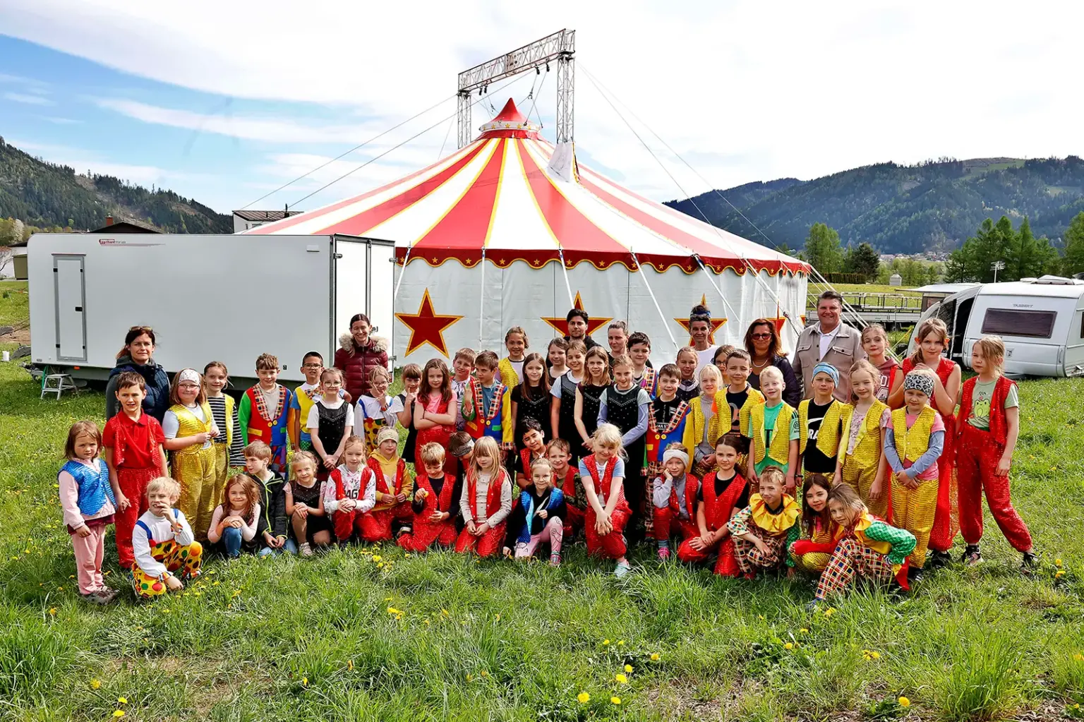 EIne große Gruppe von Kindern vor einem Zirkuszelt