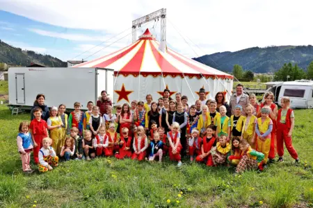 EIne große Gruppe von Kindern vor einem Zirkuszelt