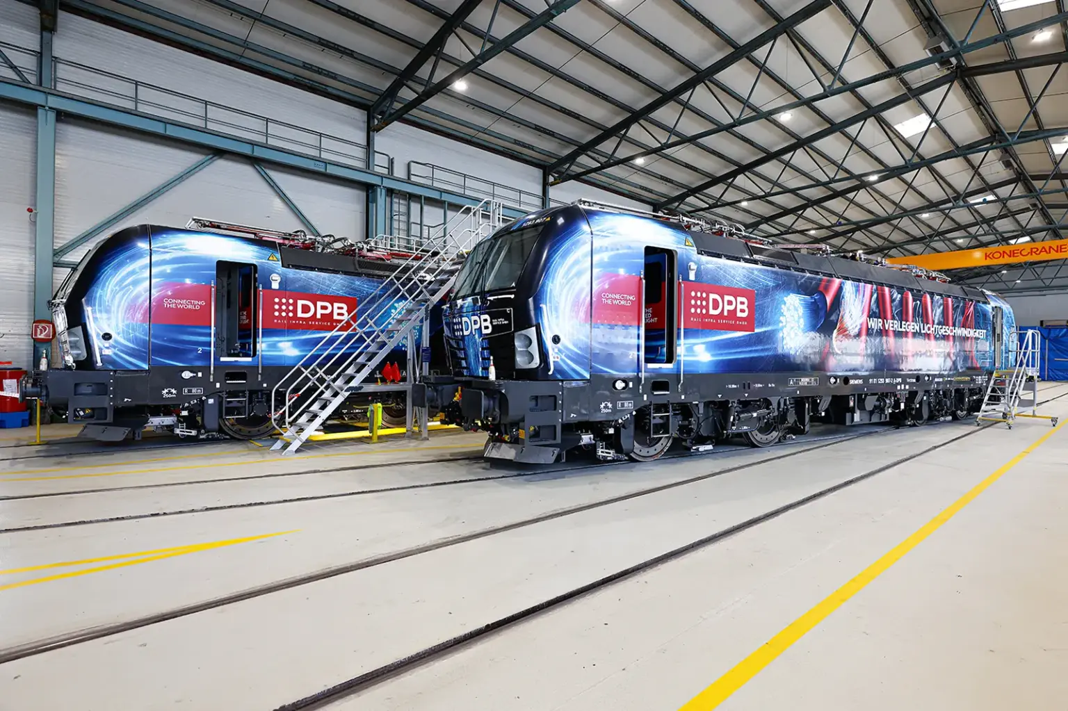 Zwei Lokomotiven stehen in einer Halle