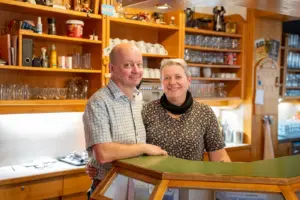 Ein Mann und eine Frau stehen hinter einem Gasthaustresen