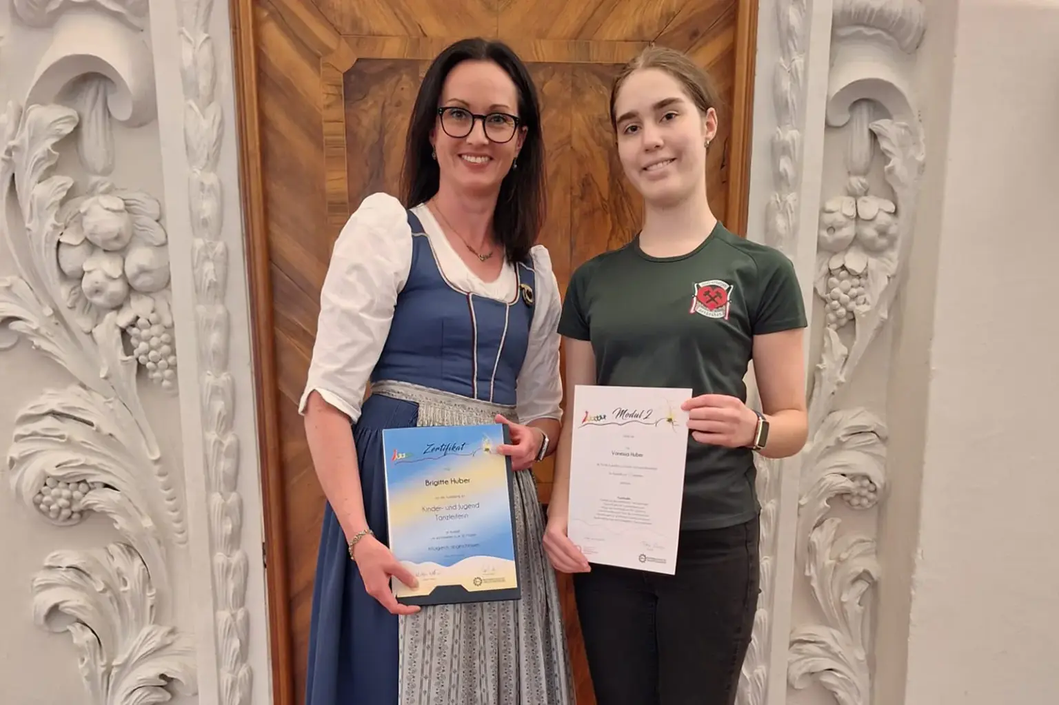 Zwei Frauen präsentieren Urkunden