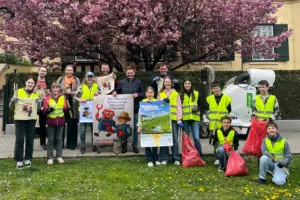 Eine Gruppe von Jugendlichen und Erwachsenen mit Plakaten und Müllsäcken