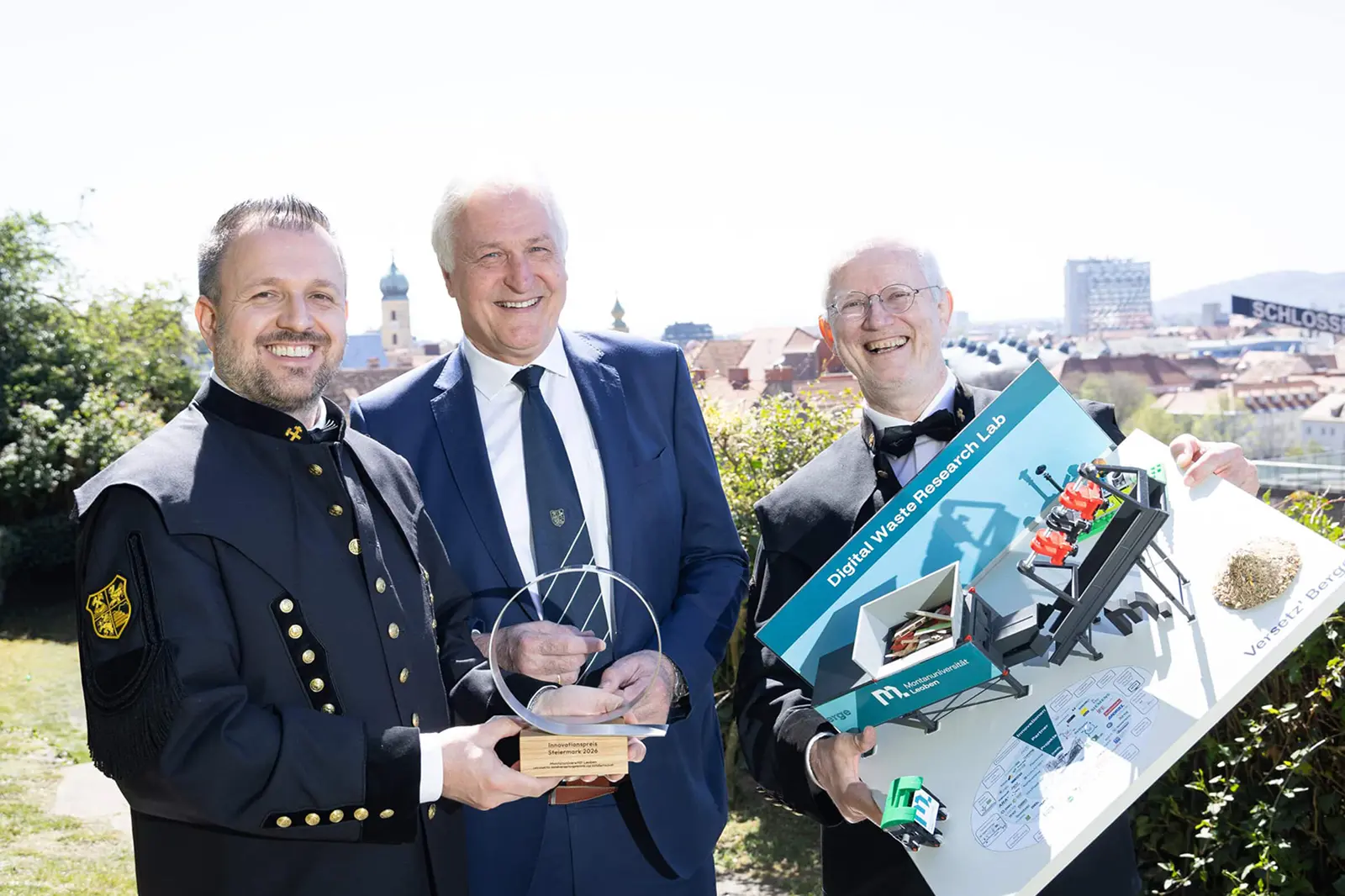 Drei Männer präsentieren eine Auszeichnung