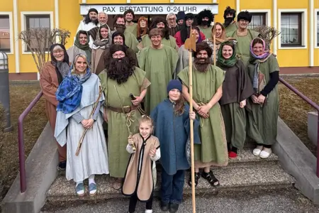 Eine Gruppe von Personen in Kostümen steht auf einer Treppe vor einem Gebäude