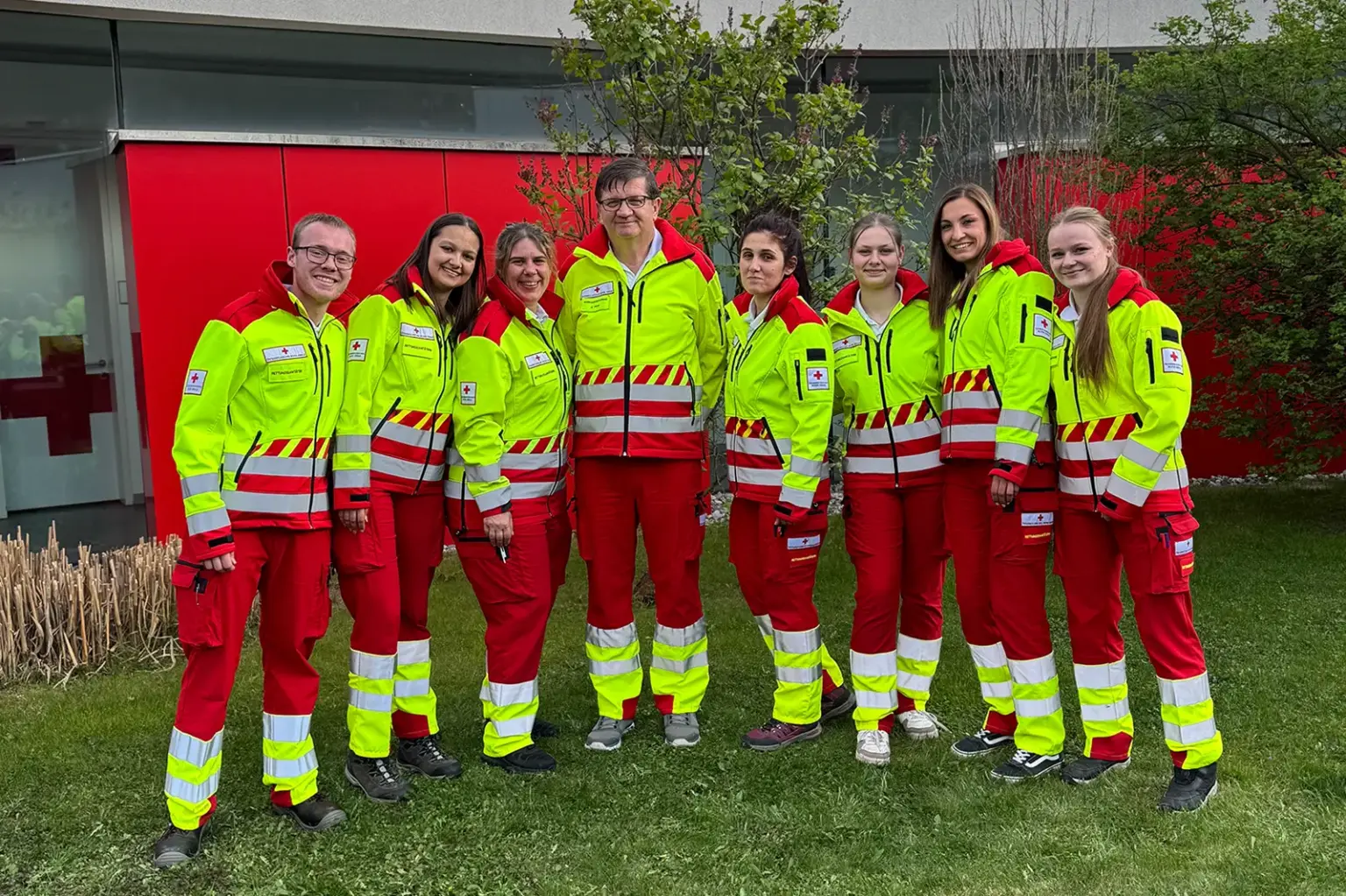 Acht Personen in Uniform stehen auf einer Wiese