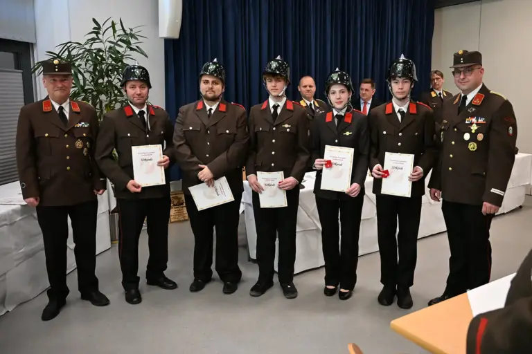 Sieben Männer in Uniform mit Urkunden